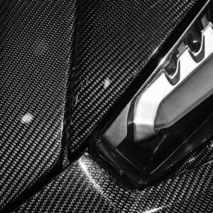 Dettaglio di un body kit in carbonio su un'auto premium in atelier